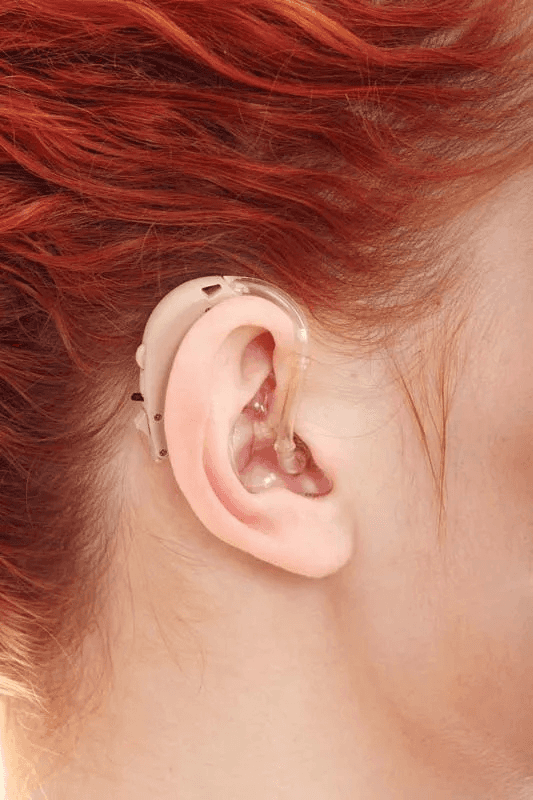 Audiologist fitting a hearing aid at Hearwave clinic Noida