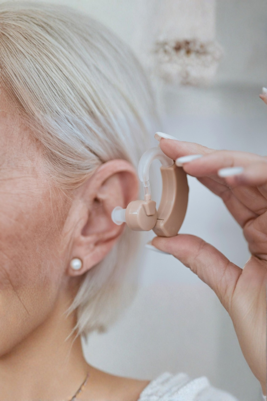 Woman adjusting hearing aid